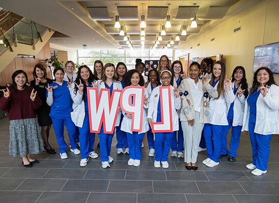 Group of 博彩平台推荐 nursing students holding the letters LPW